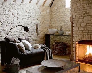 cosy living room with exposed stonework, fireplace and chaise longue