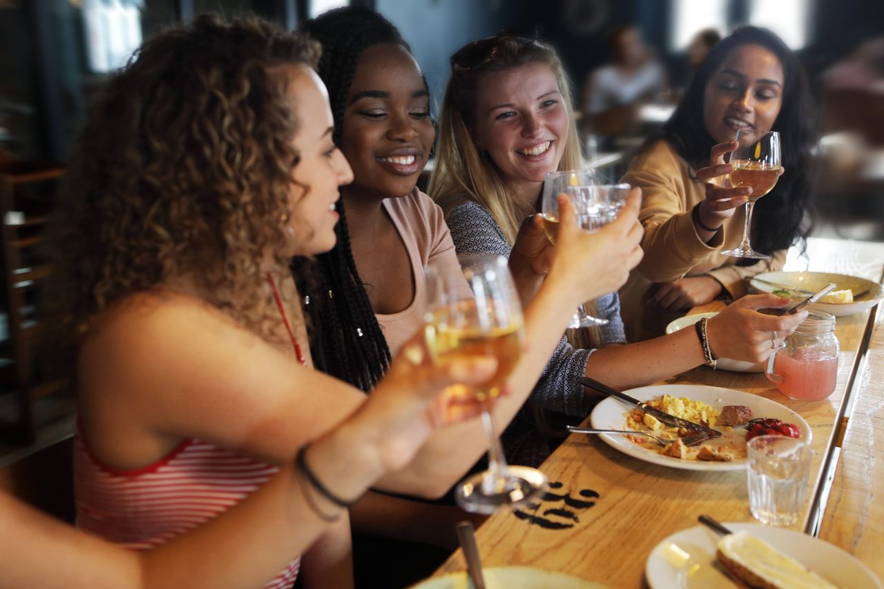 women raising their glasses - eat out to help out september