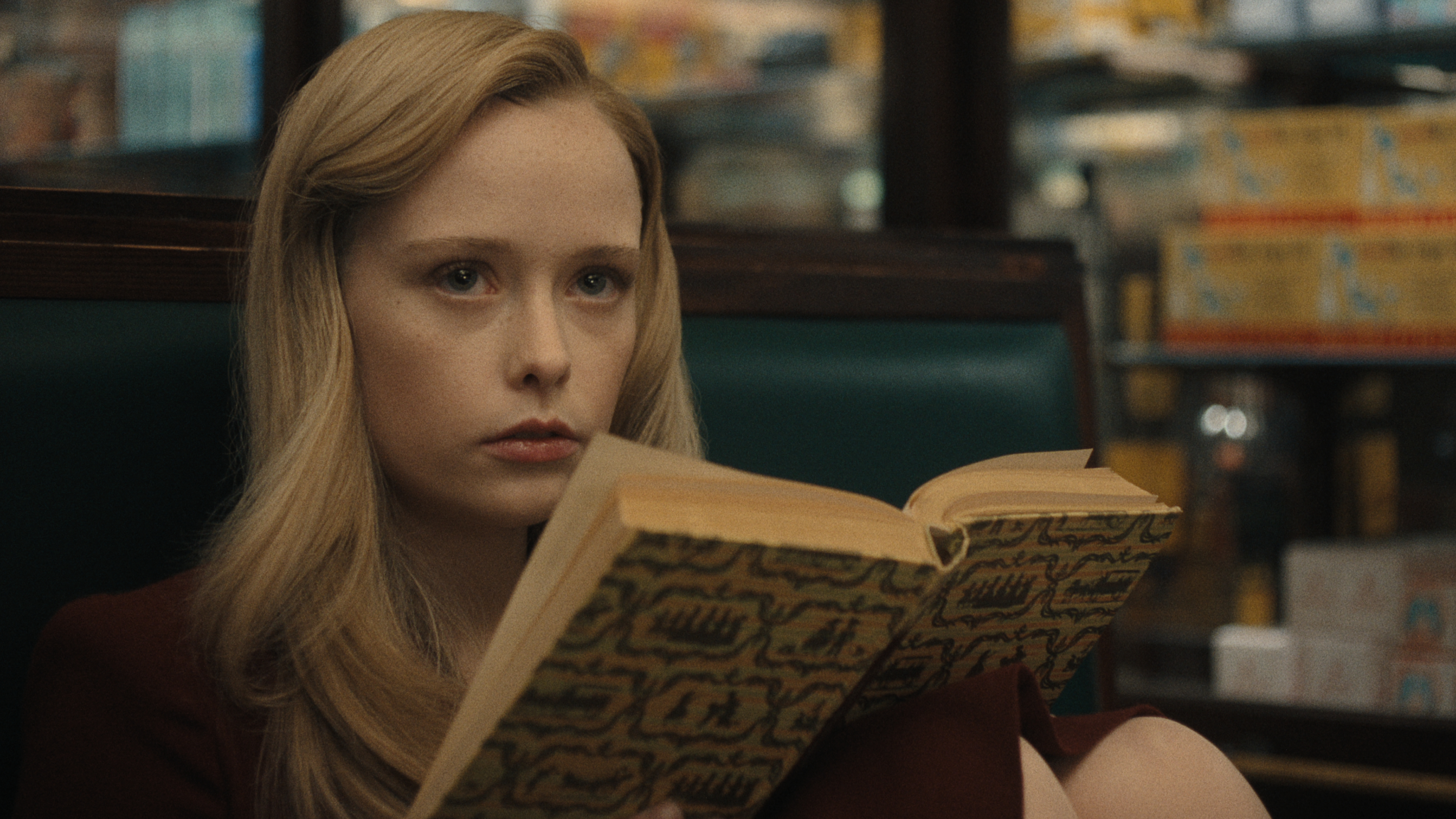 suzanna son as adeline reading a book in a still from monster the ed gein story