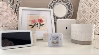 aranet4 home monitor on top of unit with decorative items and other display monitors