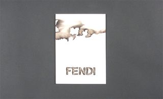 View of ﻿Fendi’s scorch effect invitation pictured against a grey background