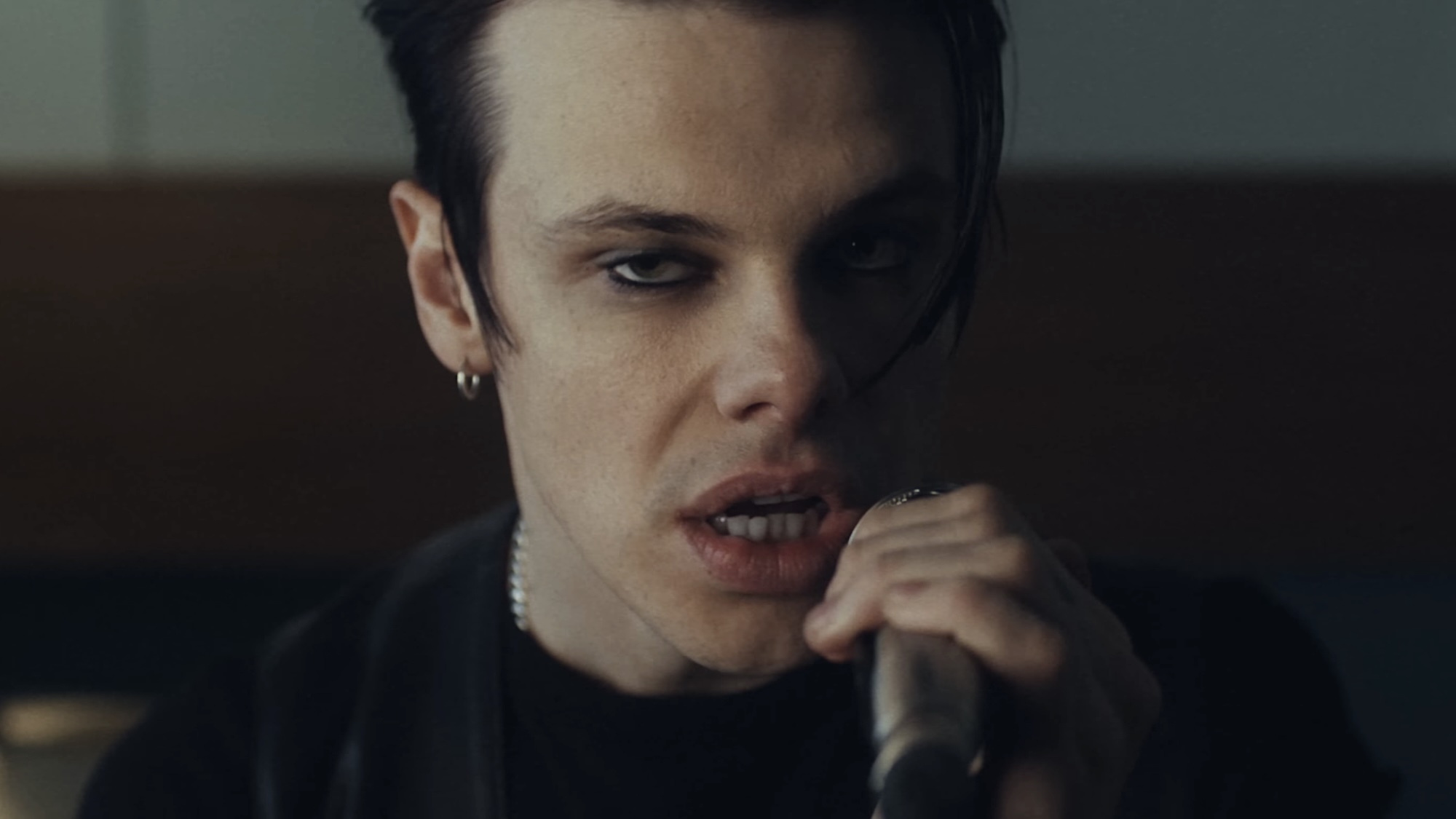 Yungblud holding microphone in music video for Zombie