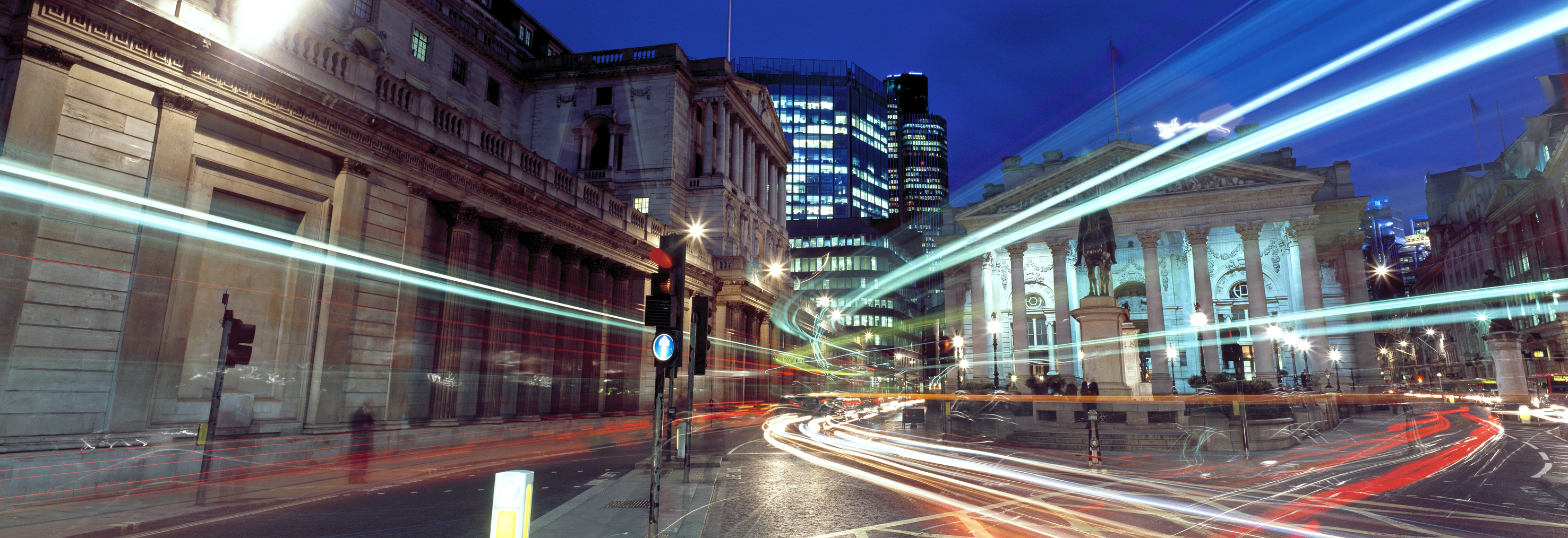 Bank of England with traffic in foreground and blurred lights from timelapse photo.