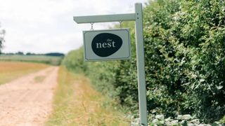 sign marking The Nest in a hedge