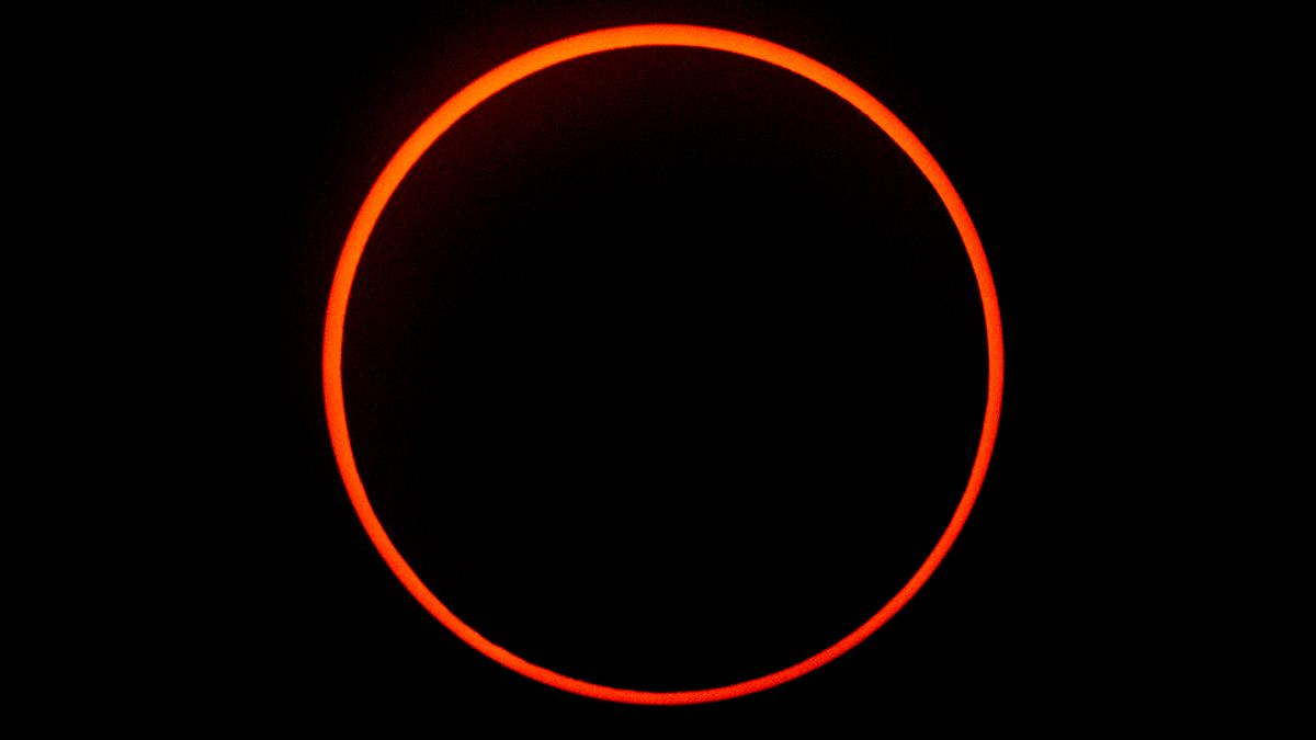 The moon is silhouetted by the sun during a solar eclipse.
