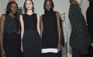 3 female models in black wool clothing pose for the camera