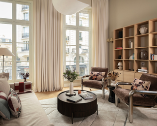 Neutral modern apartment with accent armchairs, couch and styled coffee table