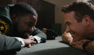 Lil Rel Howery and Ryan Reynolds lying low during a bank robbery in Free Guy.