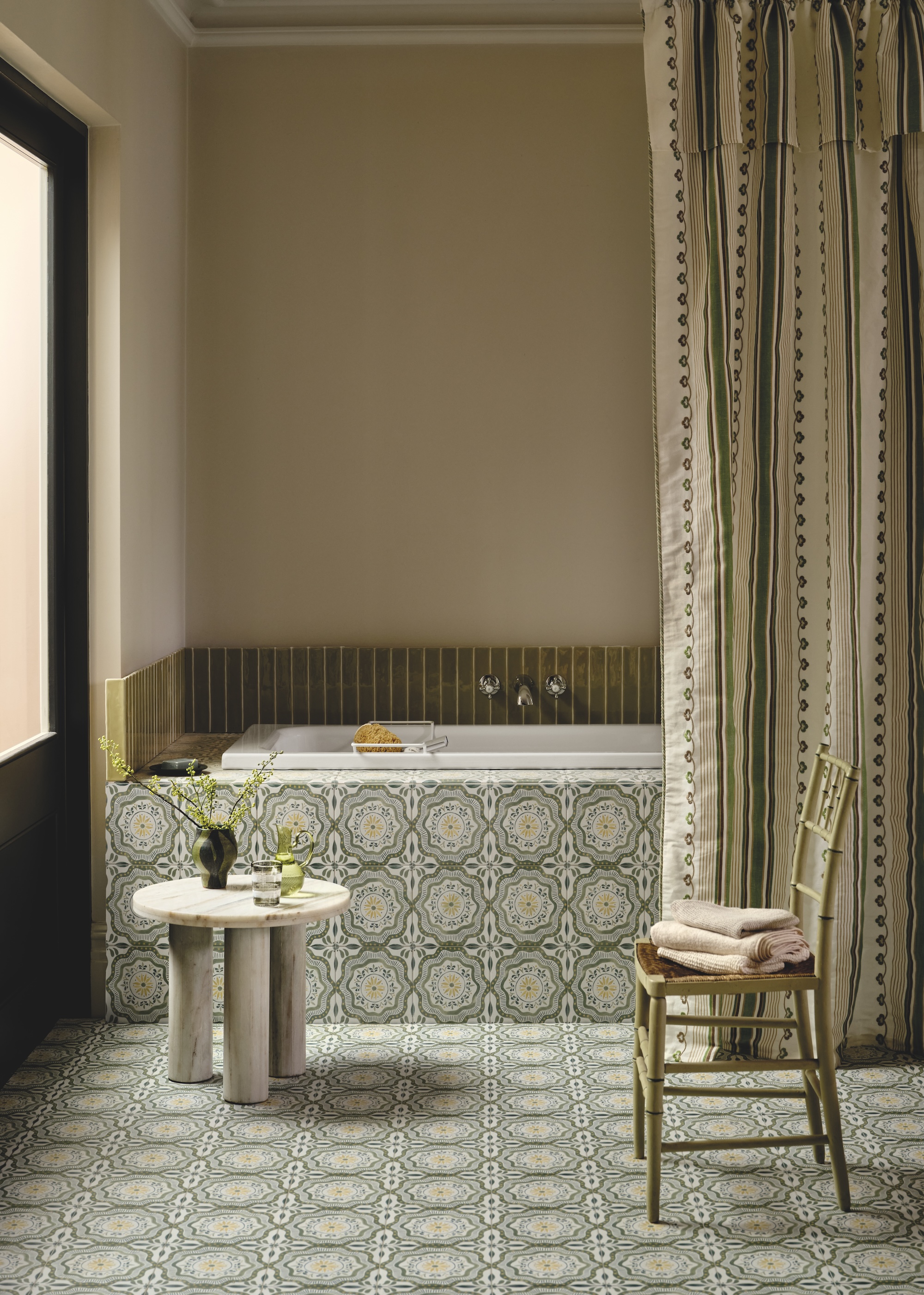 a bathroom with a patterned floor and bath panel tiles with a shower curtain