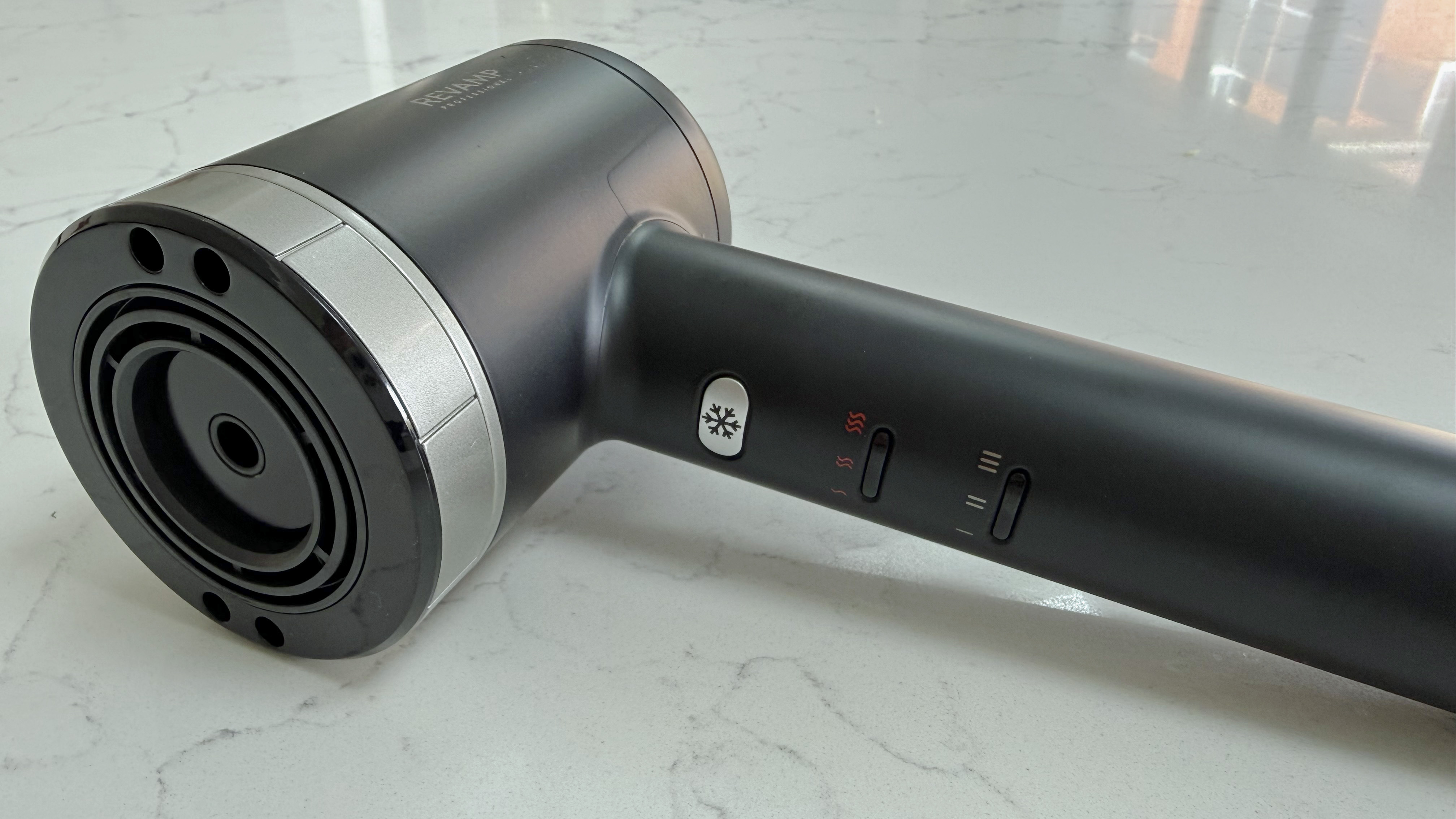 Angled view of the Revamp Tri-Care hair dryer showing the front barrel and control switches on the handle