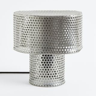 A metal mesh lamp with holes in it
