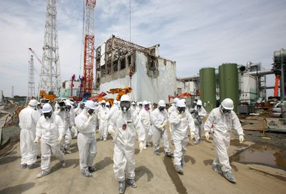 TEPCO members clean up at the company's Fukushima Dai-Ichi nuclear power plant.