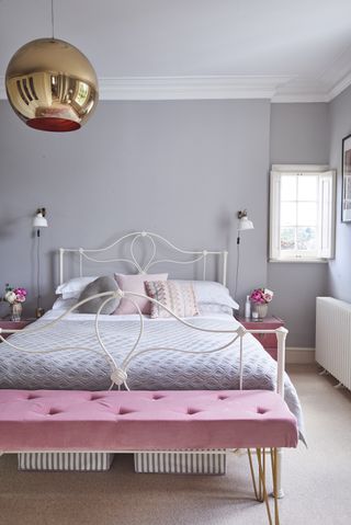 Grey master bedroom with white iron bed and pink details