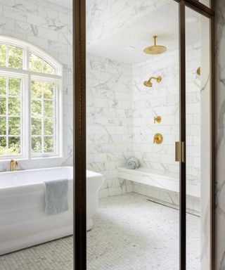 Marble bathroom with walk in shower and large white bath tub