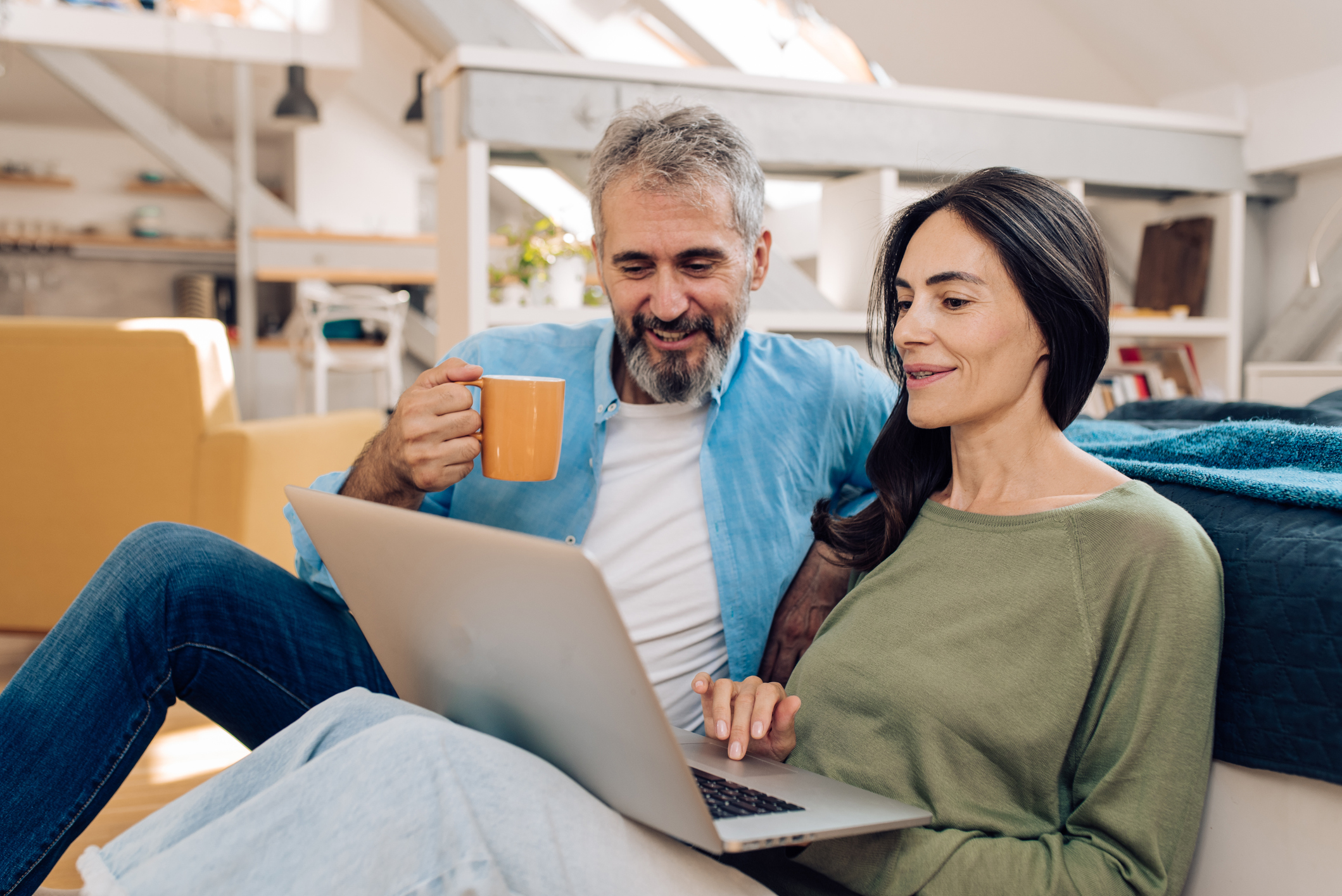Mature couple working from their living room.