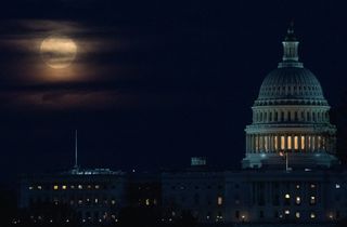 The Super Wolf Moon is seen as it rises behind the clouds above the U.S. Capitol, on March 9, 2020, in Washington.