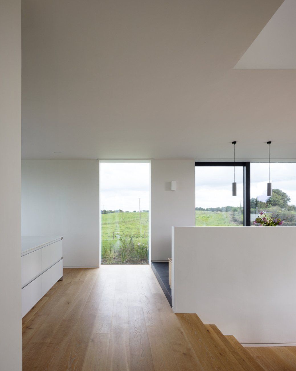Inside a modern home with white walls and large windows
