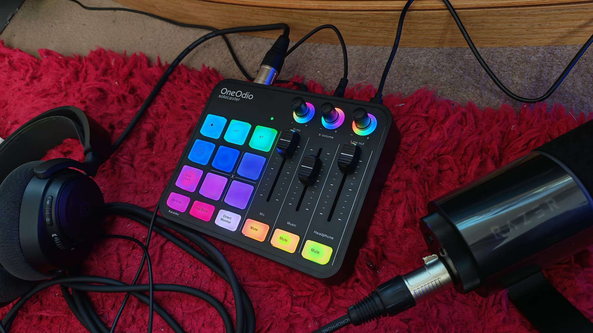 A OneOdio Solocaster next to a gaming headset and a Razer microphone