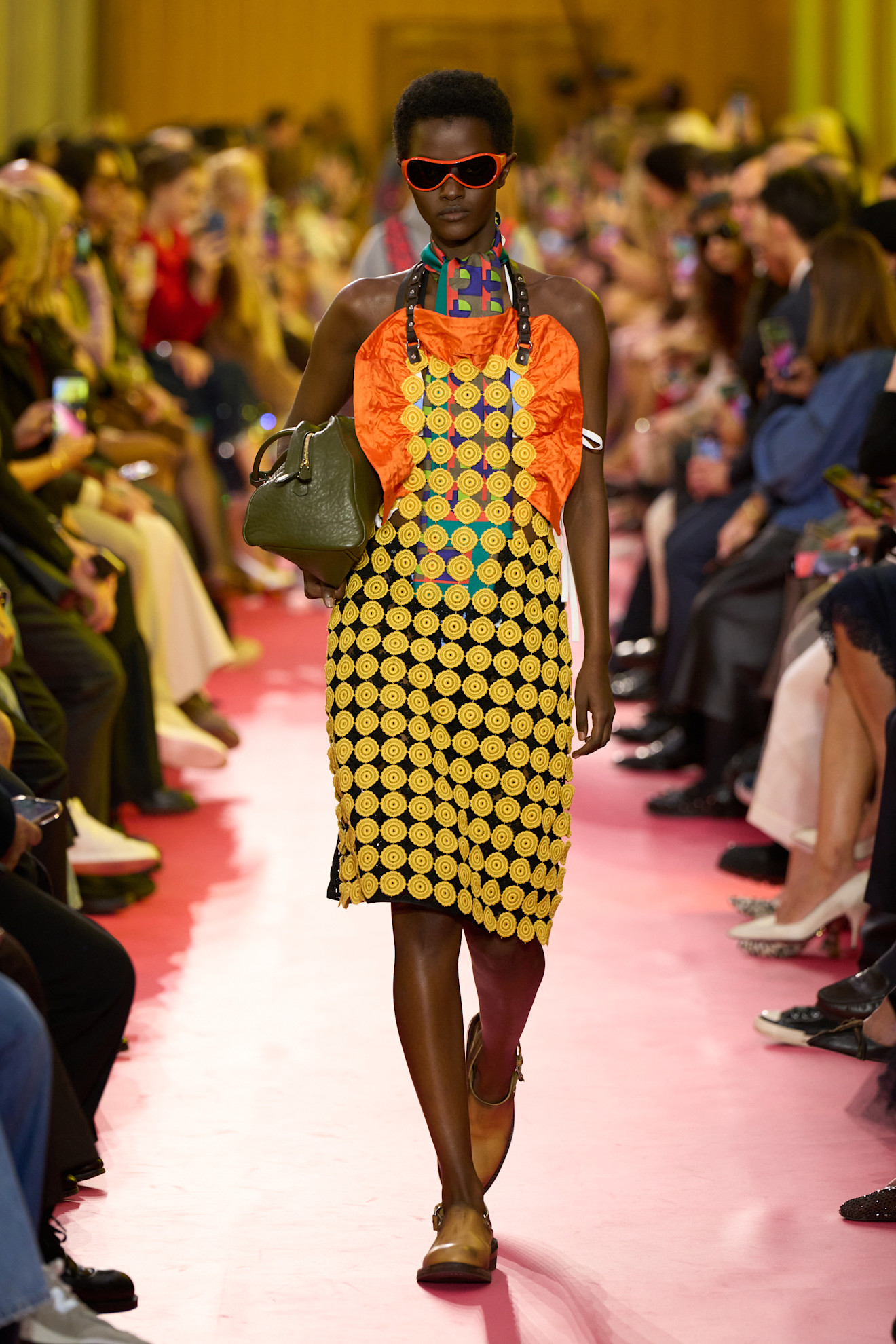 Model in a yellow and orange outfit on the Miu Miu runway.