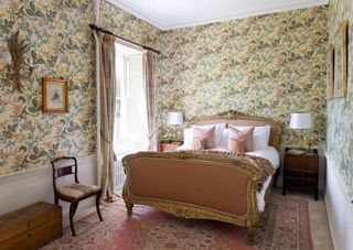 pink bedroom with floral wallpaper and pink and gold bed