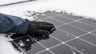 Solar panels on house roof in winter surrounded by snow