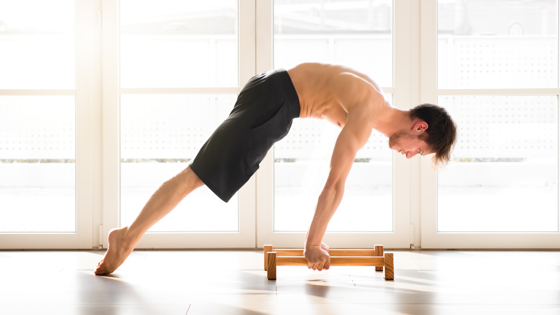 Pria Melakukan Gerakan Planche Calisthenics di papan tinggi dengan kaki dari tanah