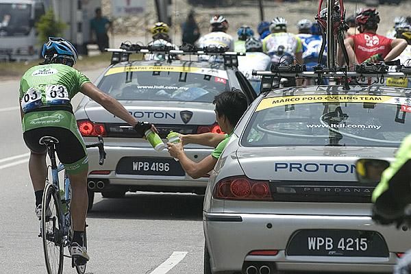 Yilin Liu (Marco Polo Cycling Team) from China takes on-board some fresh bidons for his teammates up ahead.