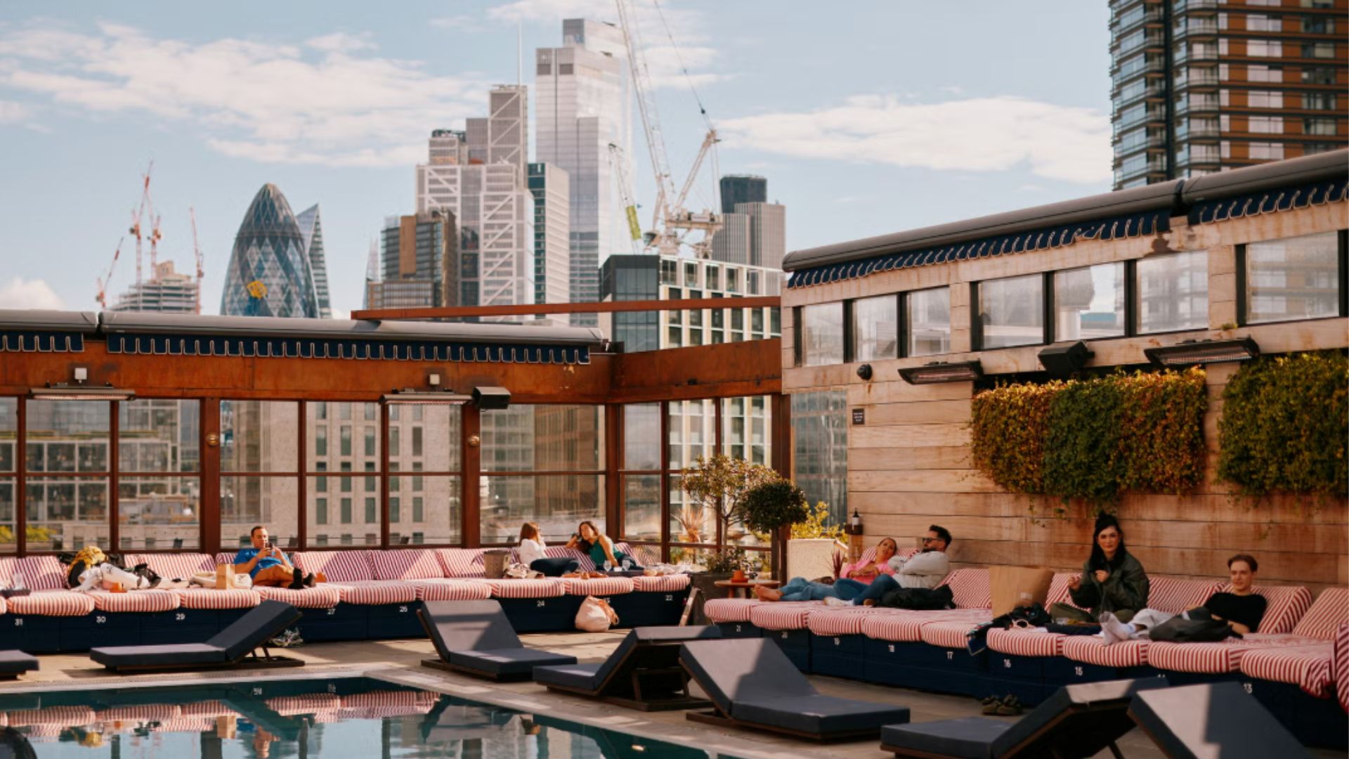 an image of the rooftop pool with the london skyline behind it