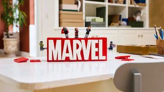 Lego Marvel Logo and Minifigures set on a white desk