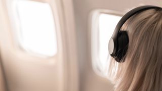 A woman wearing headphones on a flight