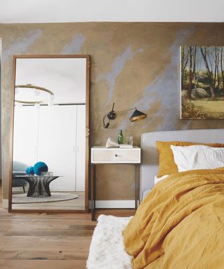 Textured wall. Full length mirror, yellow gold bedding