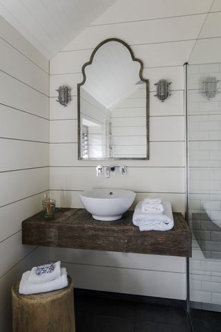 bathroom with wooden floating shelf and pedestal sink