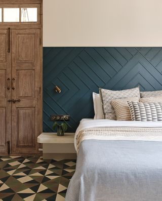 A bedroom with painted floor tiles