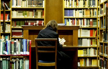 A woman reads in a library.
