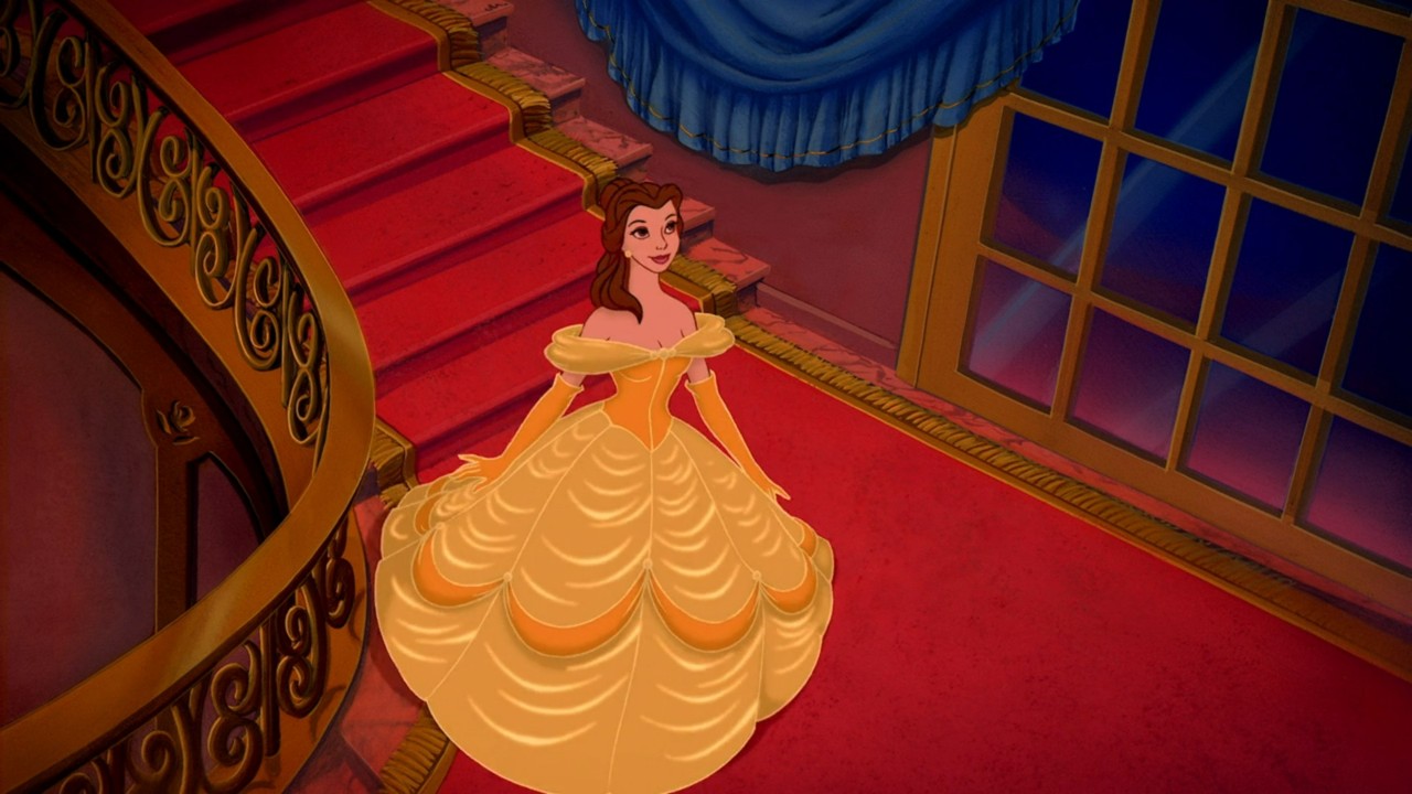 Belle descends the stairs in her iconic yellow dress in Beauty and the Beast
