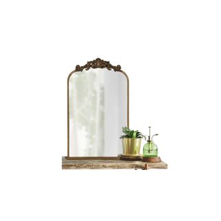 Anglo Arch Metal Wall Mirror in antique gold on a shelf with a plant and watering can