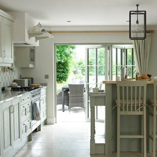 Bifold patio doors off a kitchen, with light coloured frames internally to match the kitchen decor