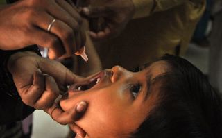 Pakistani child receiving polio vaccine, public healthcare