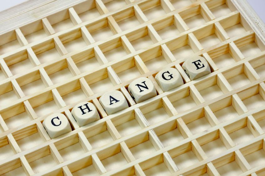 The word &quot;change&quot; is spelled out in wooden letter cubes on a wooden grid.