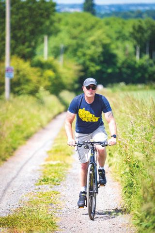 Mark Hodson riding his bike along a farmland trail