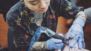 Nomi Chi tattooing someone
