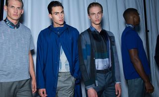 Four models wearing grey and blue Brioni clothing