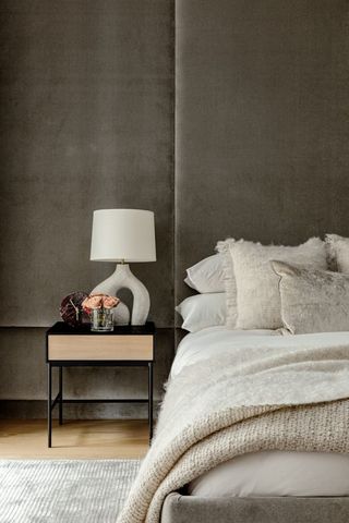 Grey bedroom with velvet upholstered wall