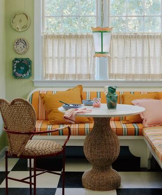 An eclectic kitchen with an orange sofa and pendant light