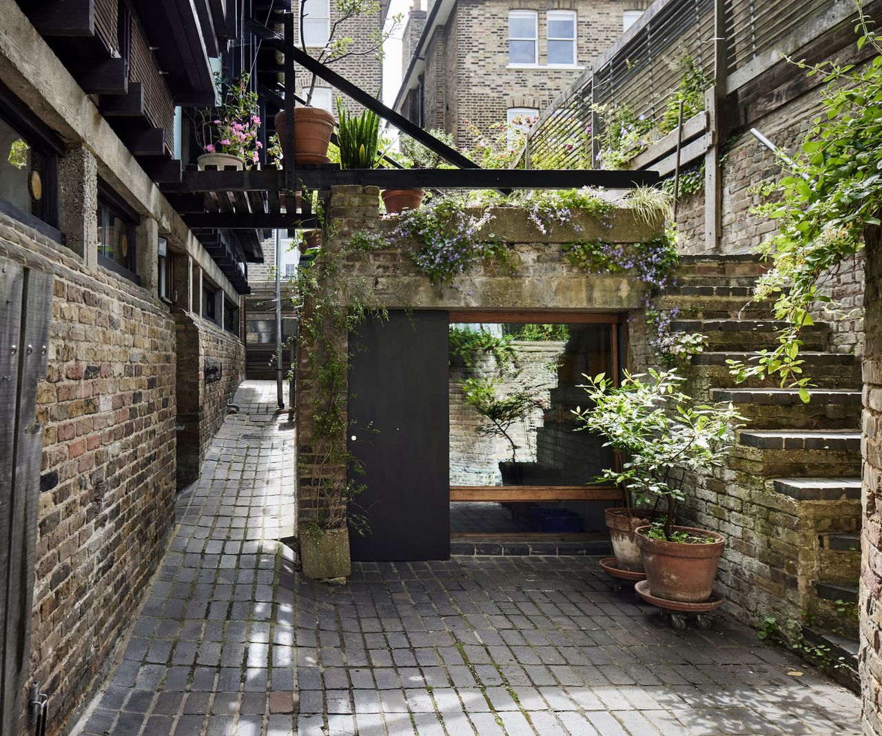 Stone cobbled garden and a staircase leading upstairs