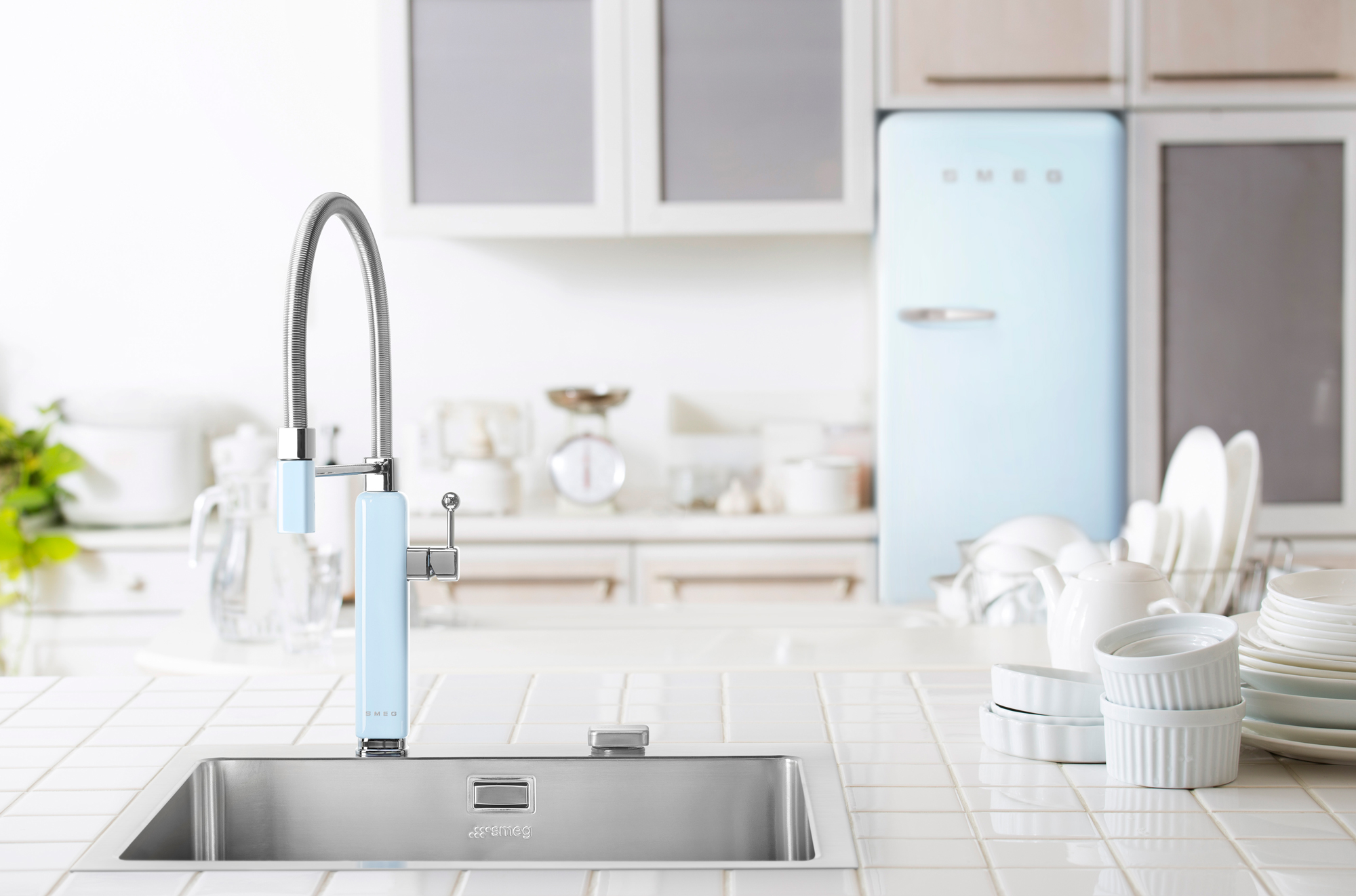 a light blue kitchen tap in a kitchen with a matching fridge