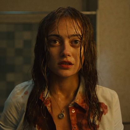 ella purnell as rhiannon in sweetpea looking into the mirror with blood on her shirt