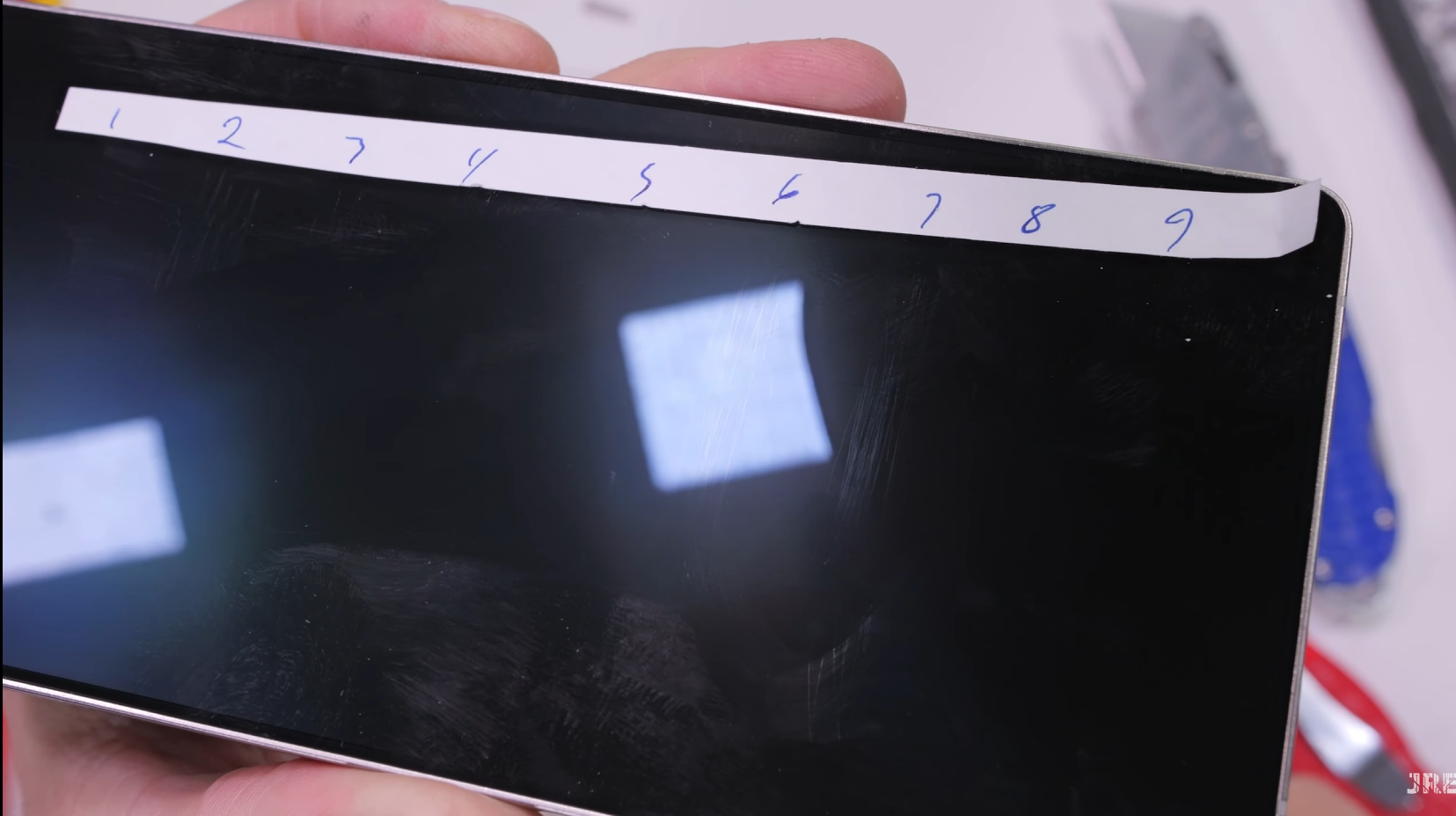 Screenshots from JerryRigEverything's Samsung Galaxy S25 Ultra durability test video.