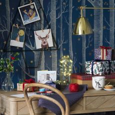 Blue wall with wooden desk and wrapped present on top