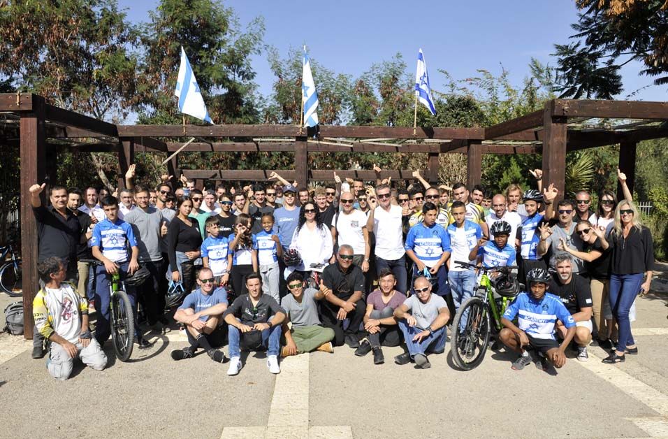 The riders pose with the students after the ceremony